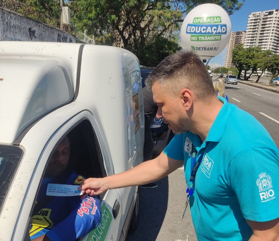 Leonardo Cavalcante, agente da CET-Rio, distribui adesivo em blitz educativa | Foto: Vinícius Sacramento